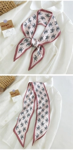 Détail d'un foulard en soie rose à motif zèbre avec une texture lisse et bordure