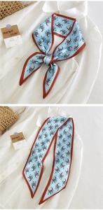 Détail d'un foulard étroit bleu à motif zèbre porté avec un chemisier blanc élégant