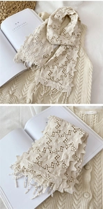 Détail d'une écharpe en dentelle beige avec motifs floraux rétro et franges élégantes