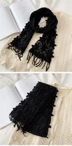 Détail de l'écharpe en dentelle noire avec broderies florales ajourées et longues franges