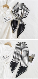 Detail view of a black and white houndstooth skinny silk scarf tied as a decorative bow