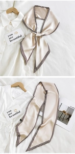 Elegant beige silk scarf featuring a houndstooth border shown tied in a bow detail