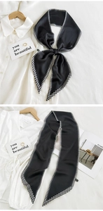 Close-up of elegant black satin neck scarf featuring a classic houndstooth pattern edge