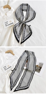 Detail of black and white paisley silk scarf used as a knotted tie and decorative ribbon