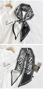 Detail of zebra pattern twilly scarf showing silky texture on a white shirt background