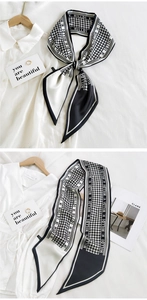 Detail of a black and white houndstooth skinny scarf with Hilldi branding on fabric