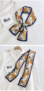Vue détaillée d'un foulard Twilly crème à motif pêches avec bords bleu marine noués