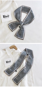Détail d'un foulard étroit en soie à motif géométrique noir et blanc sur une chemise