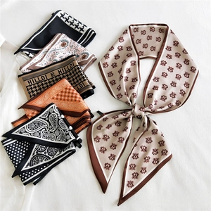 Satin silk scarf collection featuring houndstooth, floral, and monogram prints in chic earth tones