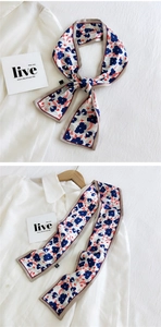Foulard twilly à fleurs de style français noué sur un col de chemise et sur un cintre en bois