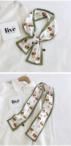 Détail d'un foulard Twilly blanc avec bords verts et motifs de lapins sur chemise