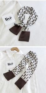Détail d'un foulard étroit en soie avec motifs géométriques et design patchwork brun