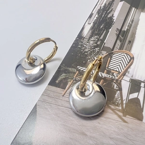 Minimalist gold and silver teardrop earrings displayed on a lifestyle fashion magazine