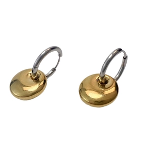 Polished silver hoops with golden pebble charms in a minimalist and trendy design