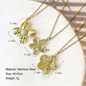 Three gold vintage stainless steel floral pendant necklaces with textured flower designs