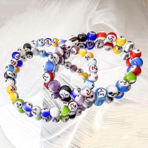 Colorful Millefiori glass bead bracelets with smiley faces on white silk background