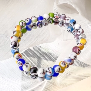Close-up of colorful millefiori glass bracelets featuring vibrant smiley face beads