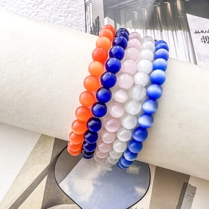 Set of five natural cat eye stone beaded bracelets in vibrant colors on a white display stand