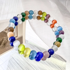 Macro shot of colorful cat eye stone beads on bracelet with glossy reflection