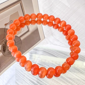 Detailed view of vivid orange cat eye beads bracelet with mirror reflection effect