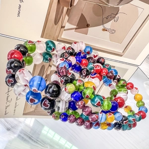 Bohemian colorful glass bead bracelets with red heart patterns on a mirror surface