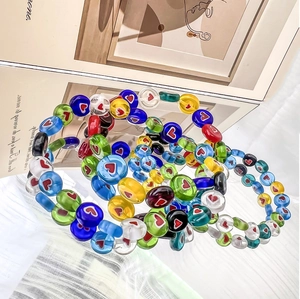 Colorful glass beads bracelets with heart patterns in vibrant layers and artistic style