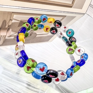 Close-up of vibrant elastic bracelet featuring colorful glass beads with heart patterns