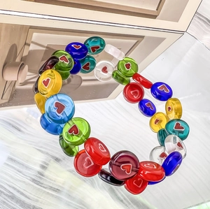 Close-up of colorful heart glass beads showing vibrant floral patterns on smooth surface