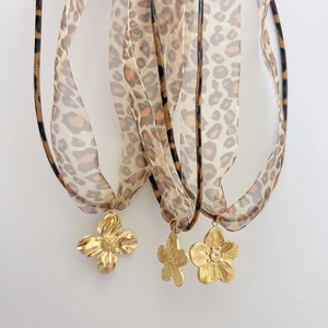Three leopard print headbands featuring elegant gold flower charms on white background