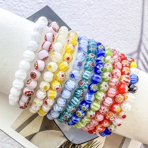 Close-up of handmade millefiori glass flower beaded stretch bracelets on jewelry stand