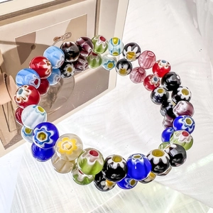 Macro view of colorful millefiori glass beads with intricate floral patterns for bracelets