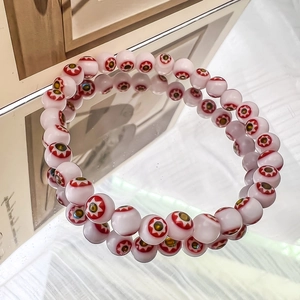 Macro shot of glass beaded bracelet with colorful millefiori evil eye flower patterns