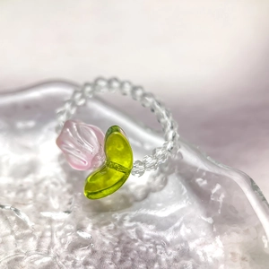 Detailed macro view of handmade crystal tulip ring with pink flower and green leaf