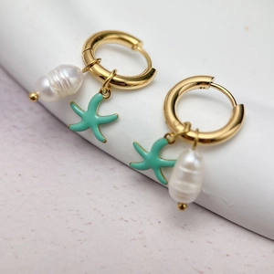 Detail of gold hoop earrings with white baroque pearl and mint green starfish charms