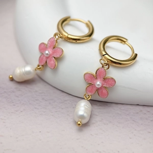 Detail of elegant gold cherry blossom earrings with pink enamel and pearl pendants