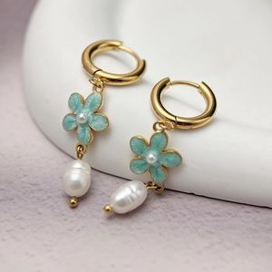 Detail of elegant gold flower earrings with blue enamel petals and baroque pearls
