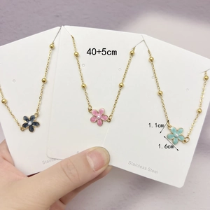Three stainless steel flower necklaces in black pink and blue on golden beaded chains
