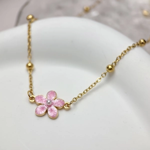 Gold beaded chain necklace with pink enamel flower pendant and pearl center details