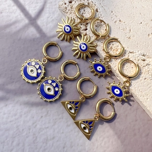 Lot de cinq boucles d'oreilles créoles dorées œil protecteur avec émail bleu