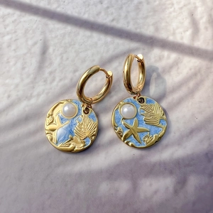 Detail of 18K gold-plated starfish earrings with blue enamel and white pearls