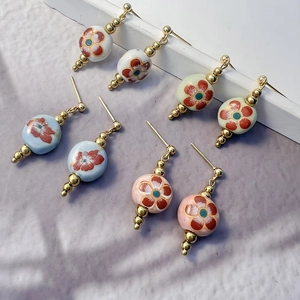 Set of four ceramic plum blossom stud earrings with gold stainless steel finish in four colors