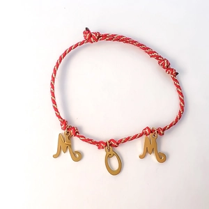 Detail of red braided rope bracelet with gold MOM letter charms on white background