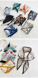 Detail of assorted long narrow scarves with floral and geometric patterns on white fabric