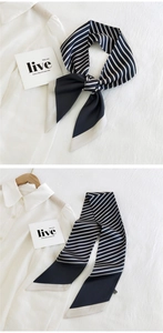 Detail of navy and white striped skinny silk scarf used as an elegant neck tie or headband