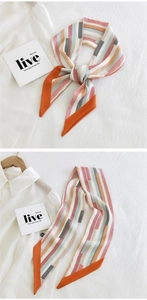 Close-up of narrow silk scarf featuring vibrant geometric stripes and orange border
