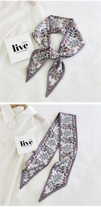 Detail of floral skinny scarf showing purple leaf print and fine edge stitching on white fabric