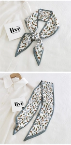 Detail of silk narrow scarf tied in a bow featuring vintage leaf prints on white fabric