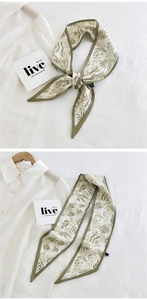 Detailed view of long skinny silk scarf with olive green botanical leaf prints and trim