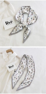Detail of narrow twilly scarf with ginkgo leaf print tied on a white shirt