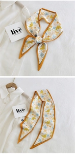 Detail of floral skinny scarf tied in a bow on white shirt with bird print accents